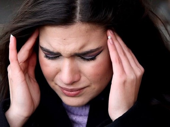 Kvinna som håller sig vid huvudet på grund av huvudvärk. Foto: Mostphotos.