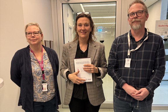 Charlotta Arwidsson (mitten) med sin avhandling. Foto: RKH