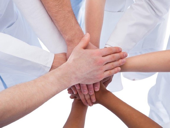 Personer som har lagt sina händer ovanpå varandras. Foto:Mostphotos