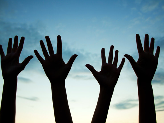 Fyra händer höjda till luften