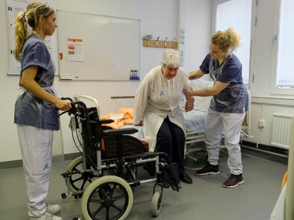 Studenter som hjälper en äldre patient. Foto: Sören Andersson