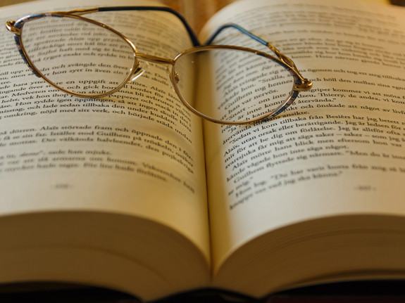 bild på en bok med glasögon ovanpå. Foto: Mostphotos.