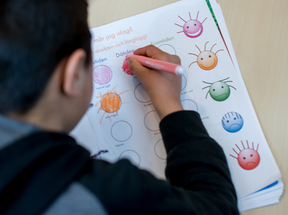 Barn som skriver med en penna. Foto:SRK