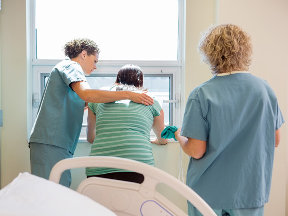 Två sjuksköterskor som tar hand om en patient med smärta. Foto: Mostphotos