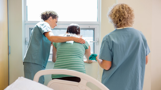 Två sjuksköterskor som tar hand om en patient i smärta. Foto: Mostphotos