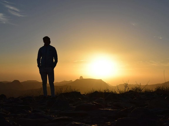 person som kollar mot solnedgång. Foto: Mostphotos