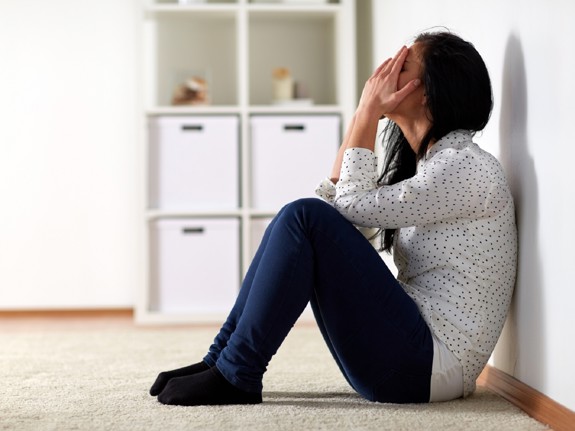 Kvinna som sitter och gråter på golvet. Foto: Mostphotos.
