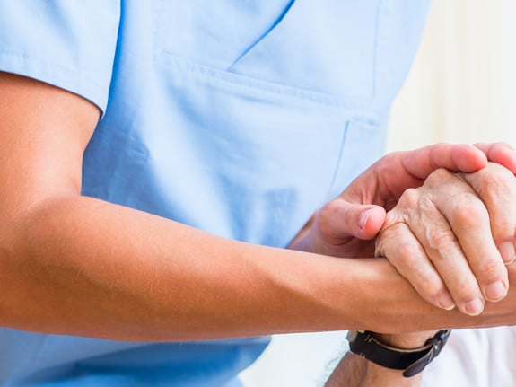 Sjuksköterska och patient som håller hand. Foto: Mostphotos