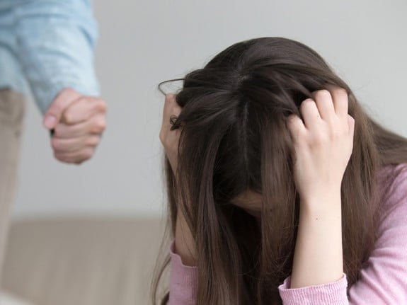 Kvinna som sitter på golvet och dras sig i håret. Foto:Mostphotos