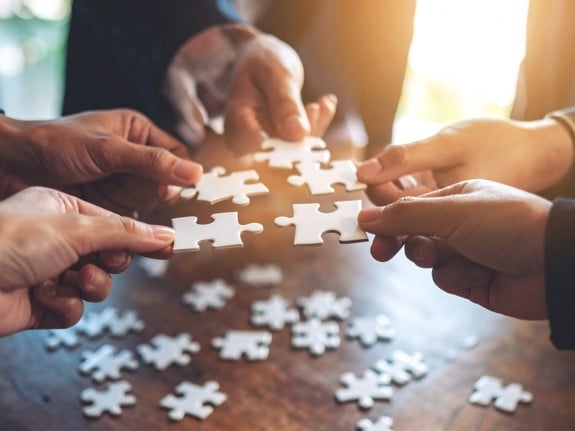 händer som lägger pussel. Foto: Firefly