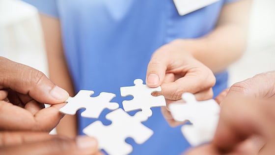personer med pusselbitar i händerna. Foto: Mostphotos.