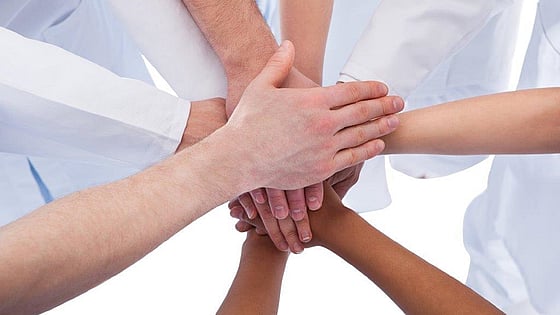 Personer som har lagt sina händer ovanpå varandras. Foto:Mostphotos