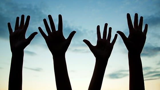 Händer som hålls upp i luften