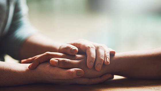 Två personer som håller om varandras händer. Foto: Mostphotos.