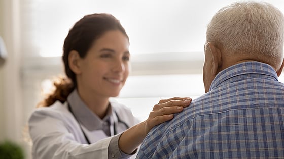 läkare håller handen på en patients axel. Foto: Mostphotos.