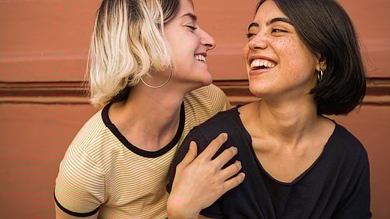 Två kvinnor som håller om varandra och ler. Foto: Mostphotos