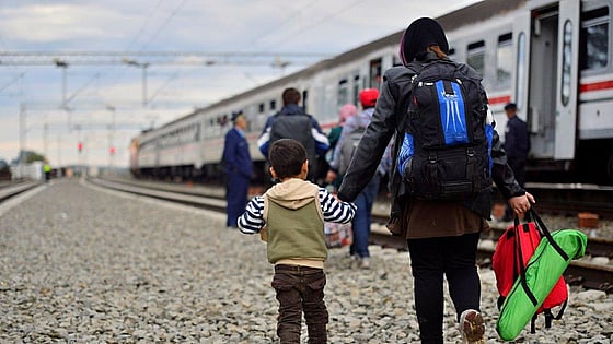 flyktingar som går vid ett tåg. Foto:Mostphotos
