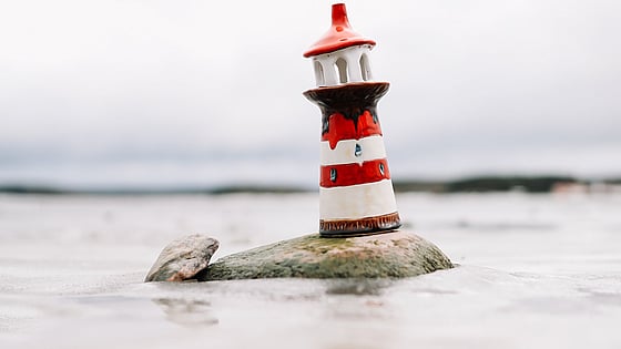 Fyrtorn som står på en klippa i vattnet