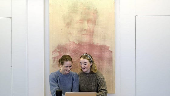 Studenter som sitter framför en tavla föreställande Emmy Rappe