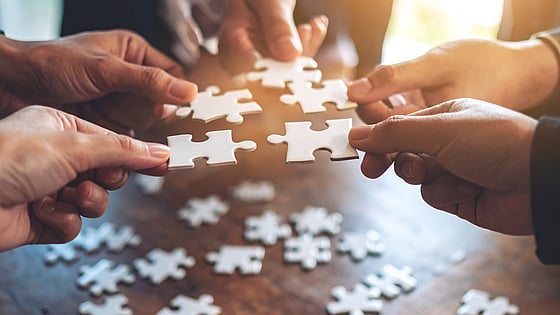 Händer som lägger pussel. Foto: Firefly