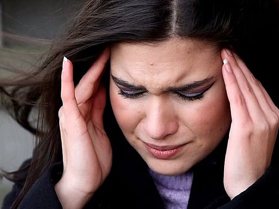 Kvinna som håller sig vid huvudet på grund av huvudvärk. Foto: Mostphotos.