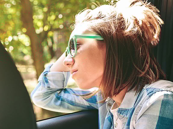 Kvinna tittar ut genom fönster. Foto: Mostphotos