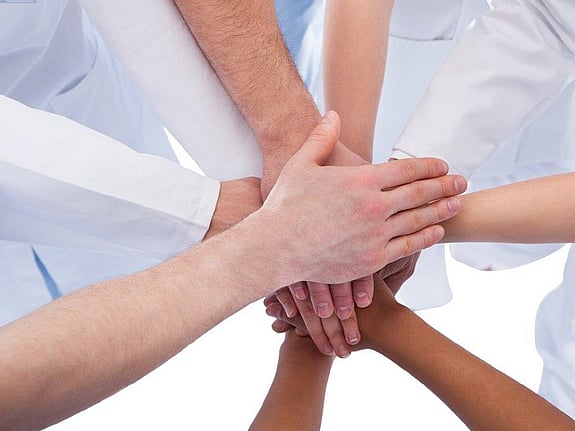 Personer som har lagt sina händer ovanpå varandras. Foto:Mostphotos