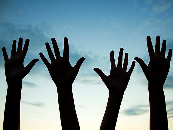 Fyra händer höjda till luften