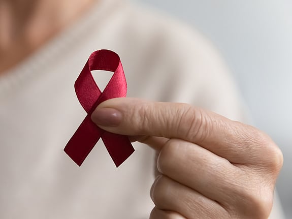 Kvinna som håller upp hiv/aids-symbol. Foto:Mostphotos