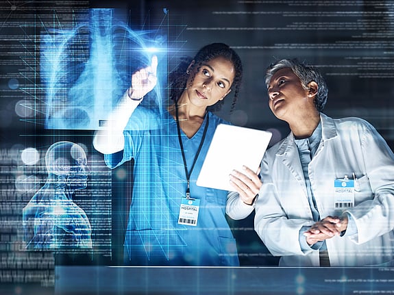 sjuksköterska och läkare kollar på en röntgenbild i 3D. Foto: Mostphotos