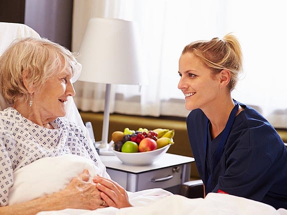 Sjuksköterska som pratar med en patient. Foto: Mostphotos