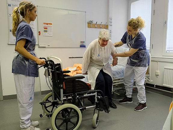 Studenter som hjälper en äldre patient. Foto: Sören Andersson