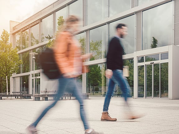 Personer som går mot en byggnad
