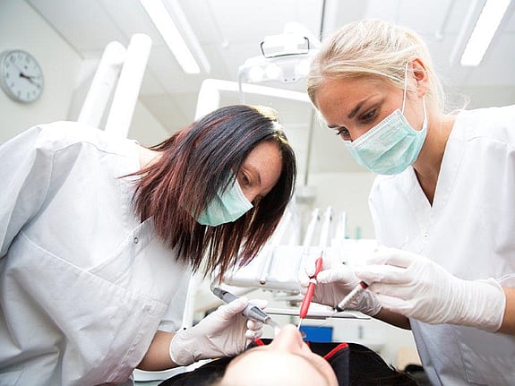 två tandläkare som jobbar med en patient. Foto:Mostphotos