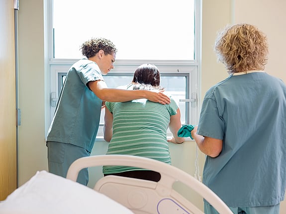 Två sjuksköterskor som tar hand om en patient med smärta. Foto: Mostphotos