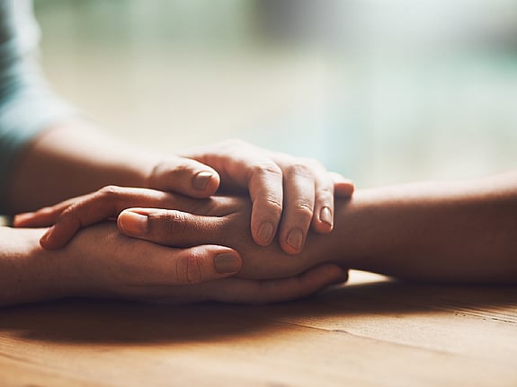 Två personer som håller om varandras händer. Foto: Mostphotos.