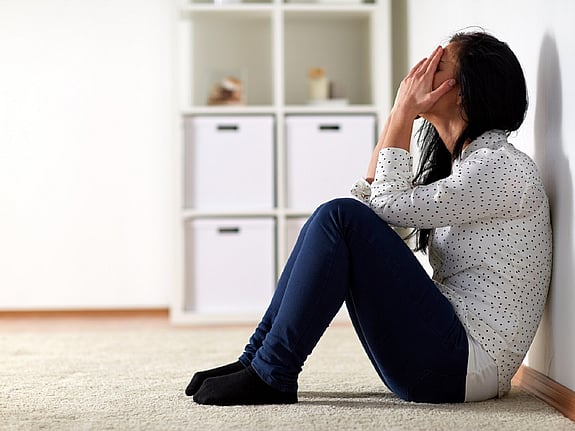 Kvinna som sitter och gråter på golvet. Foto: Mostphotos.