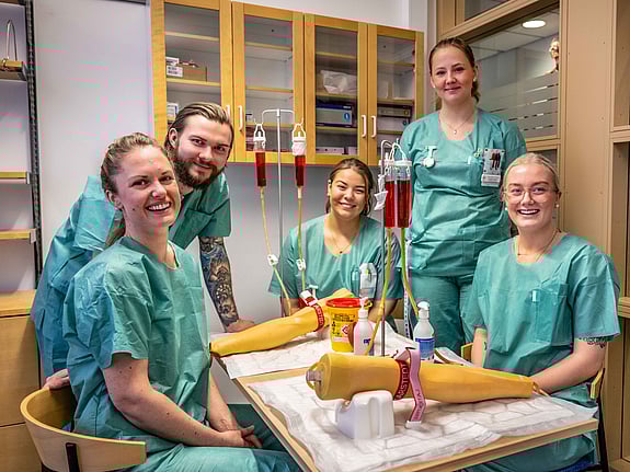 Fem sjuksköterskestudenter som övar på att ta blodprov. Foto: Jenny Frejing