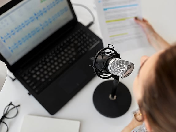 kvinna med mikrofon som spelar in en podcast. Foto: Mostphotos