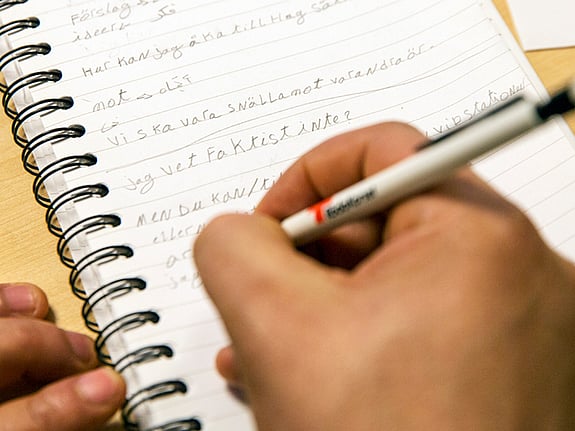 Person som antecknar på ett block. Foto:RKH