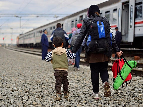 flyktingar som går vid ett tåg. Foto:Mostphotos