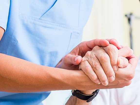 Sjuksköterska och patient som håller hand. Foto: Mostphotos
