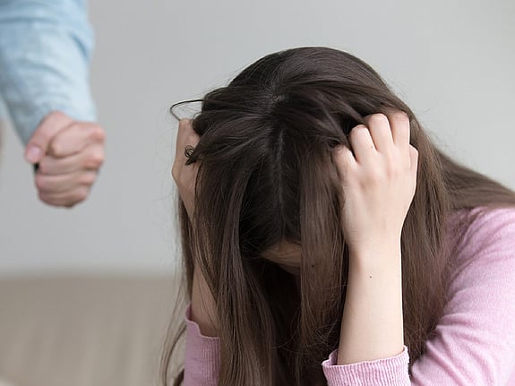 Kvinna som sitter på golvet och dras sig i håret. Foto:Mostphotos