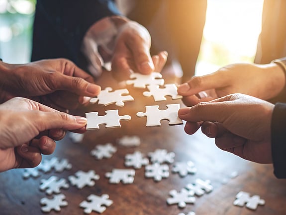 händer som lägger pussel. Foto: Firefly