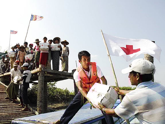 Bild av Röda Korset arbetare som lastar nödhjälp från båt.