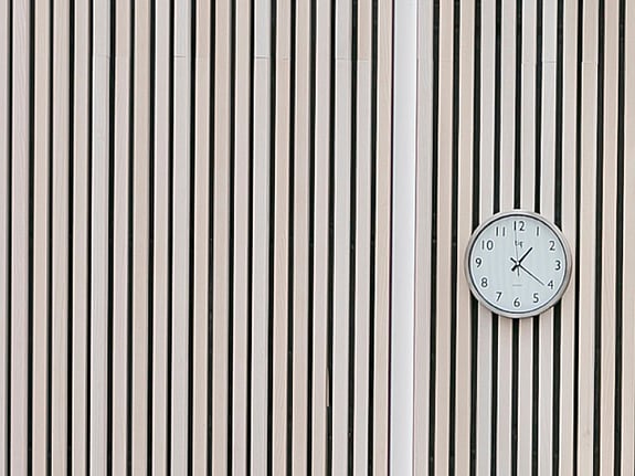 Bild av trävägg och väggklocka.